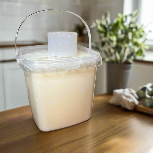 Clear container with a white lid on a wooden surface in a kitchen setting