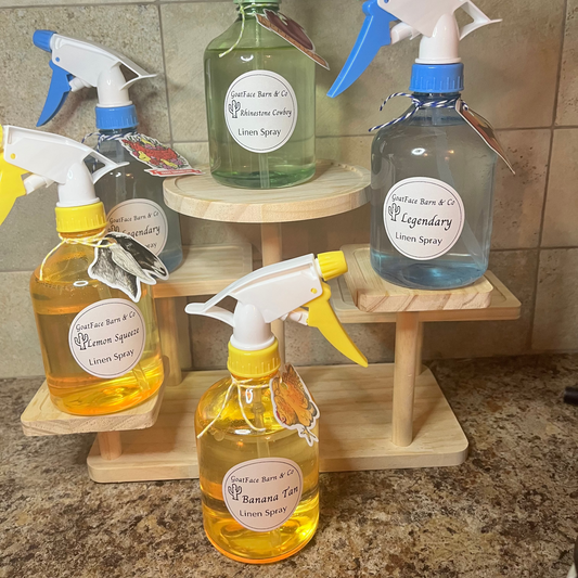 Set of cleaning spray bottles on a wooden stand with labels on a tiled wall background.