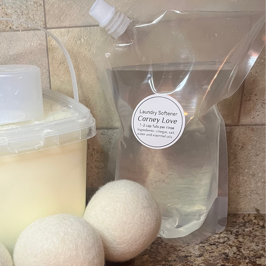 Bucket of detergent, plastic bag, and three white balls on a countertop.